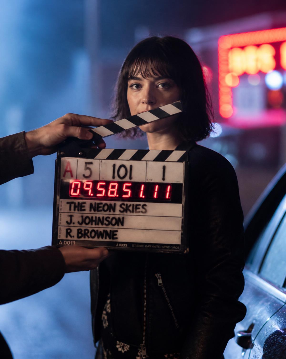 Clapperboard snapping on a neon night set
